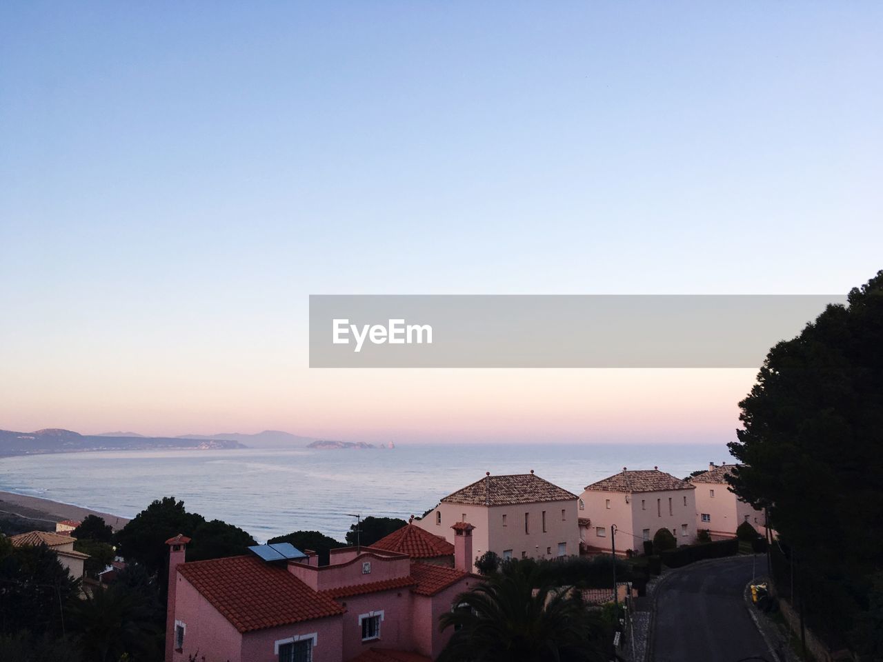 Houses against sky at sunset