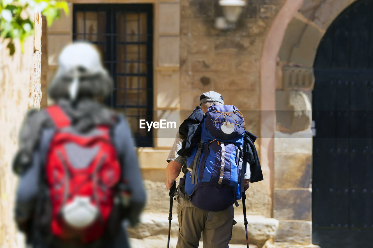 Way of st james to compostela , pilgrims with scallop shell signal in backpack