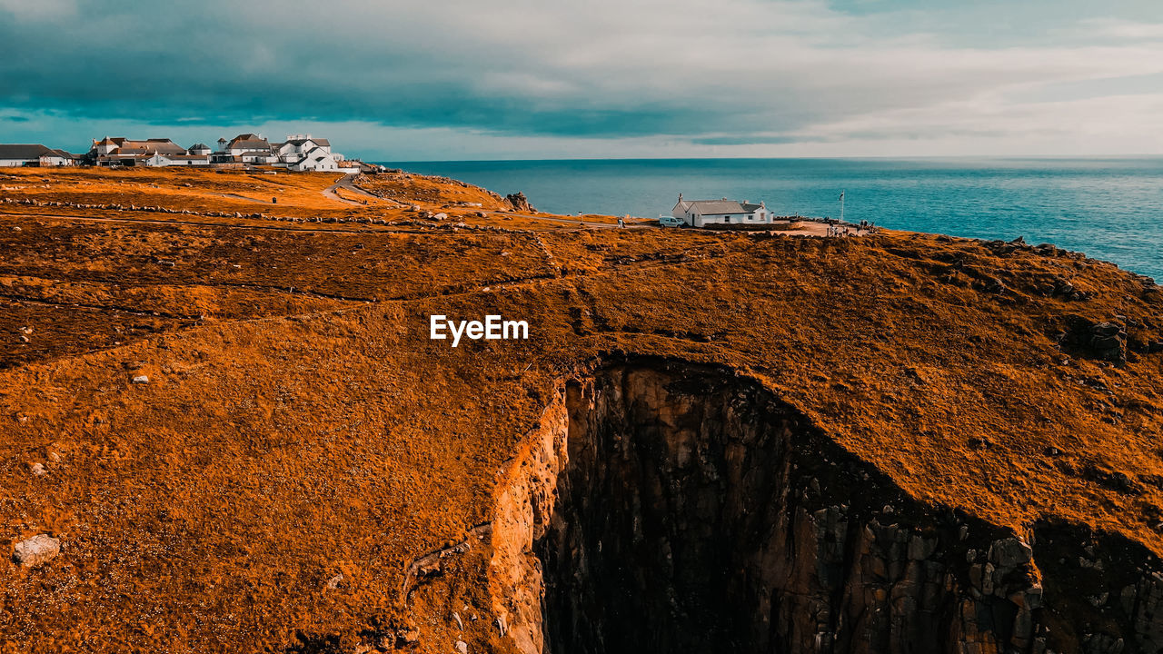 Building on the background of the ocean on top of a cliff aerial view