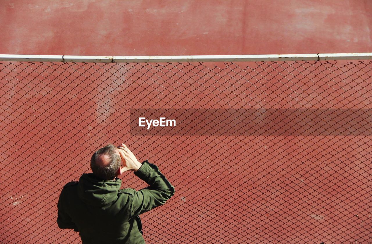 Rear view of man looking at red wall