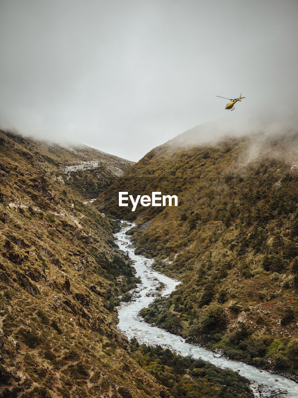 Scenic view of river amidst mountains against cloudy sky at sagarmatha national park