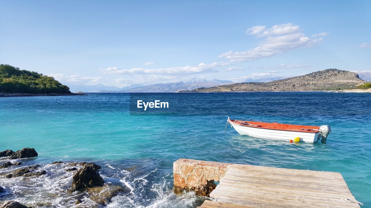 Boat moored in sea against sky