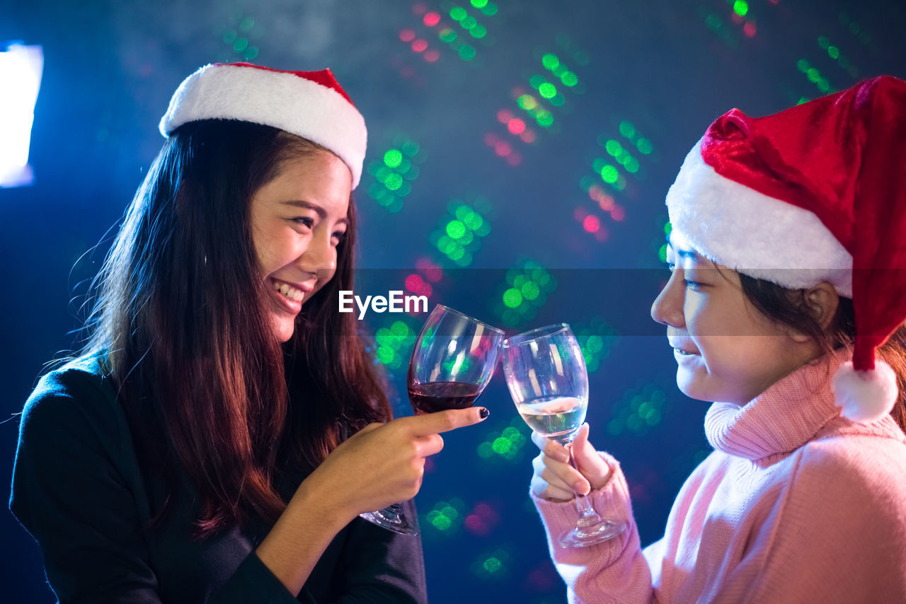 Close-up of female friends toasting during christmas