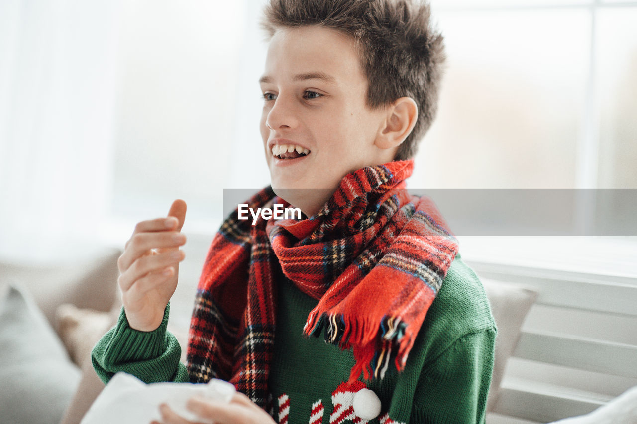 Portrait of smiling boy sitting at home