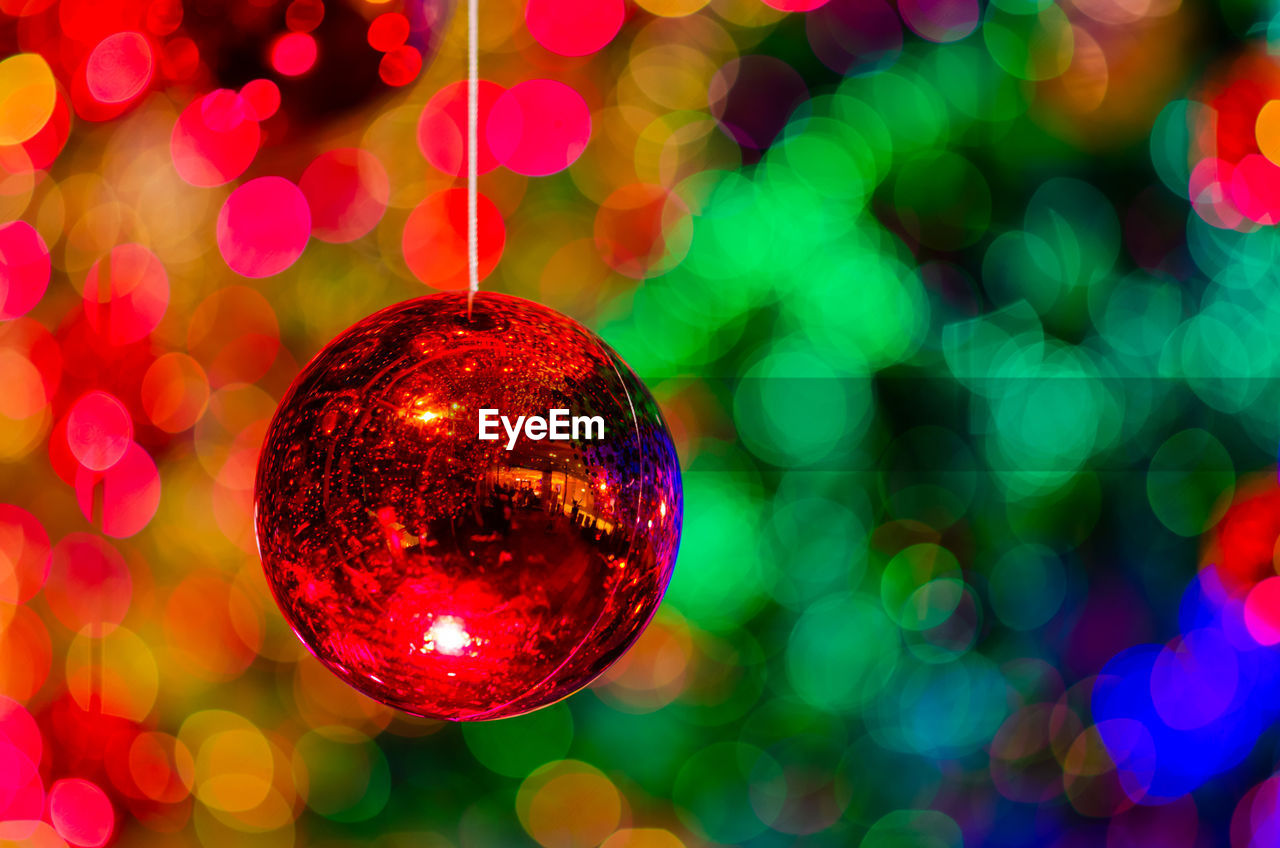 Bauble hanging to decorate for christmas holiday with colorful bokeh from light and other baubles.