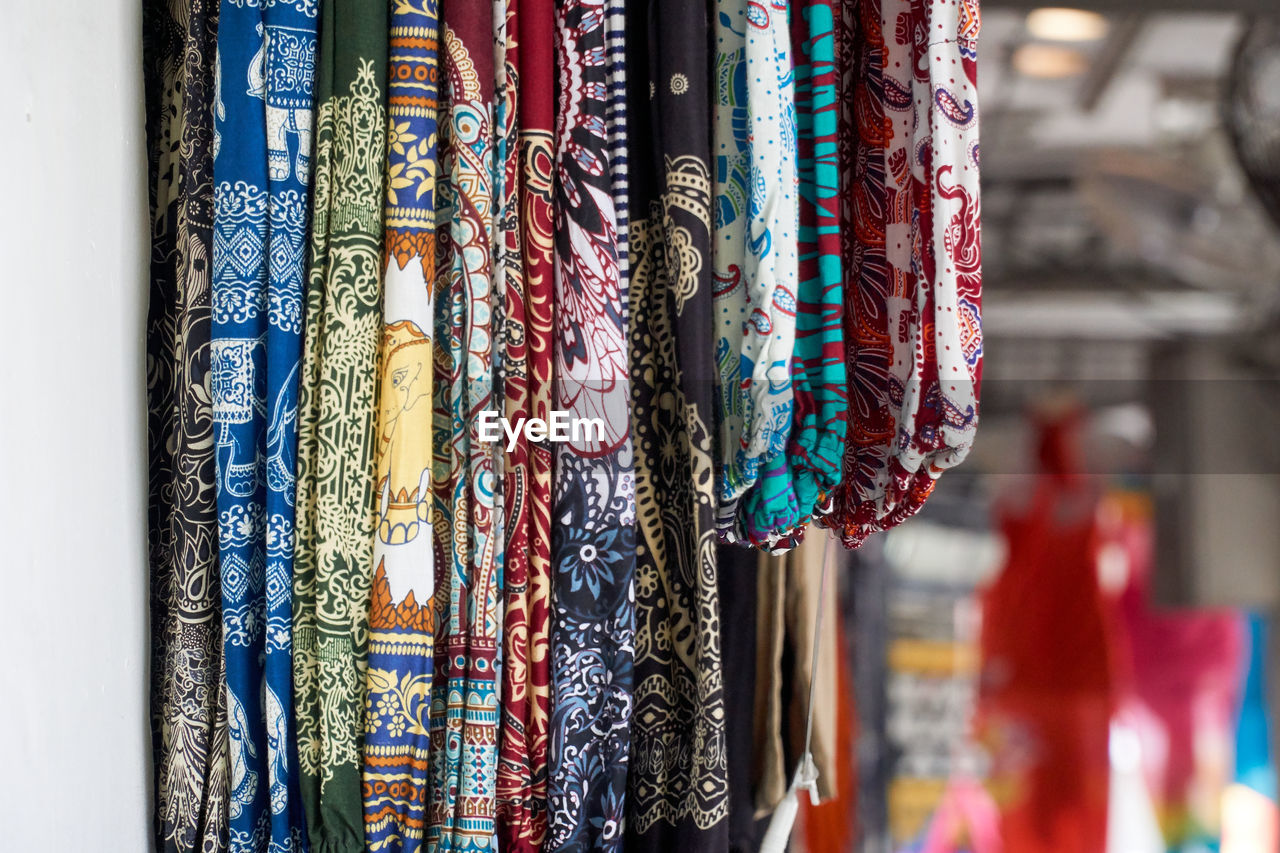 Close-up of multi colored clothes hanging at market stall