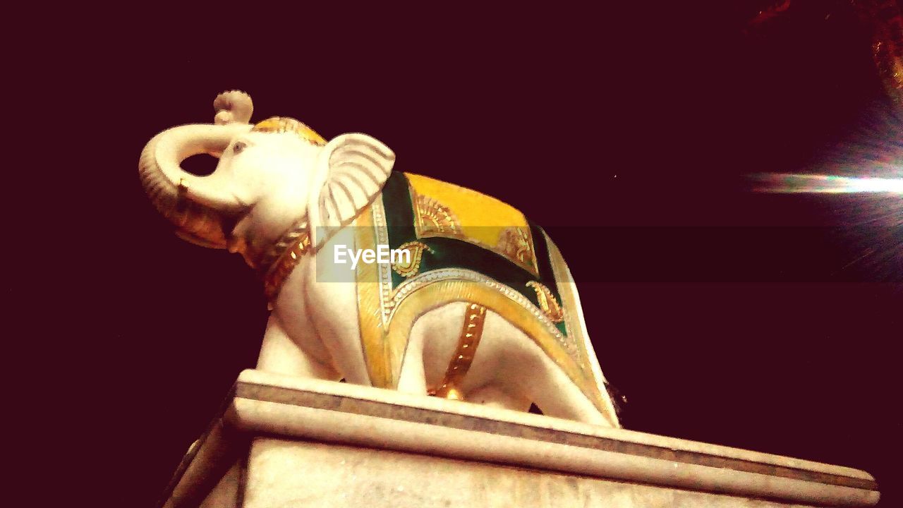 LOW ANGLE VIEW OF STATUE AGAINST NIGHT