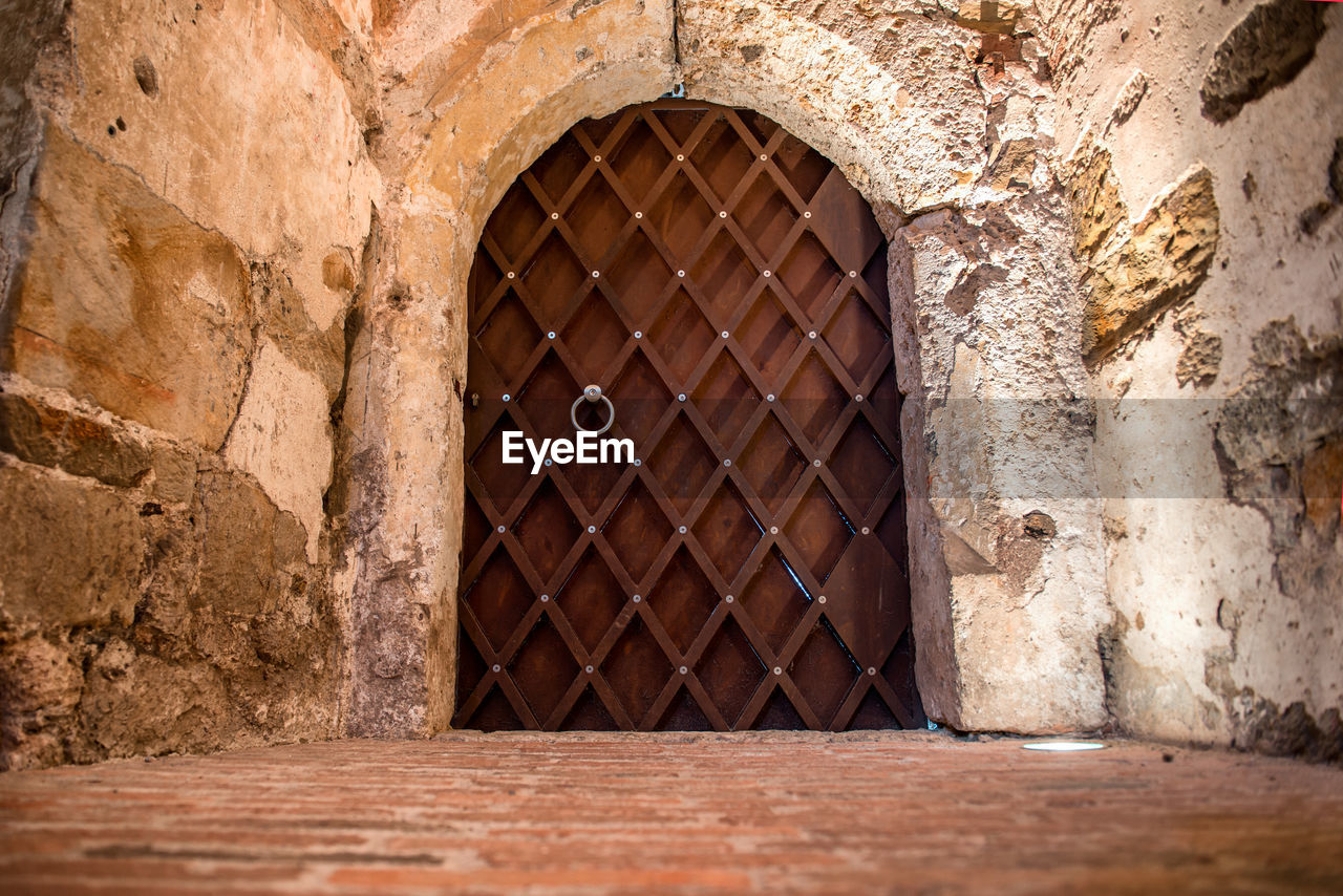 OLD BUILDING SEEN THROUGH HOLE IN WALL