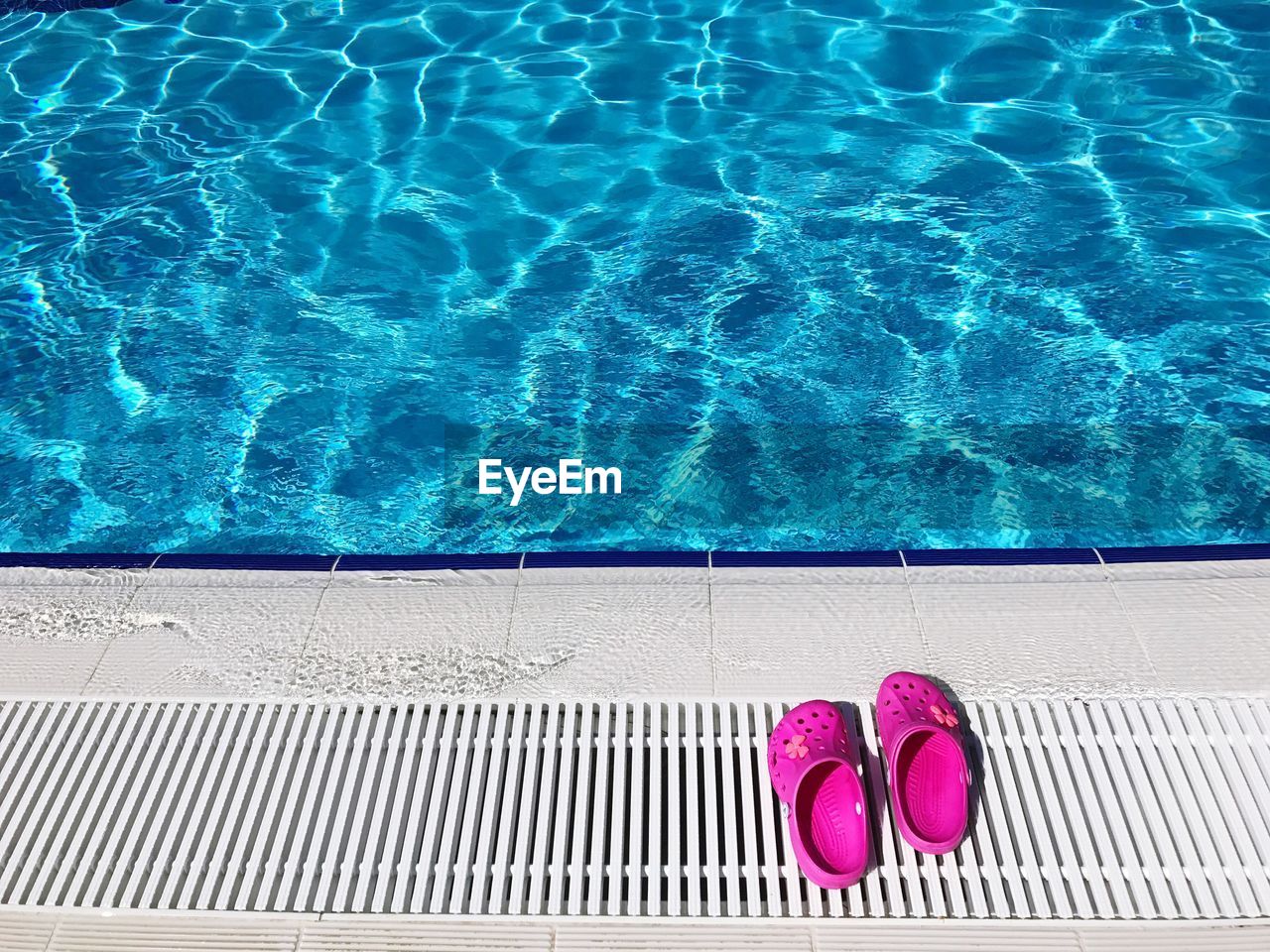 High angle view of pink footwear at poolside