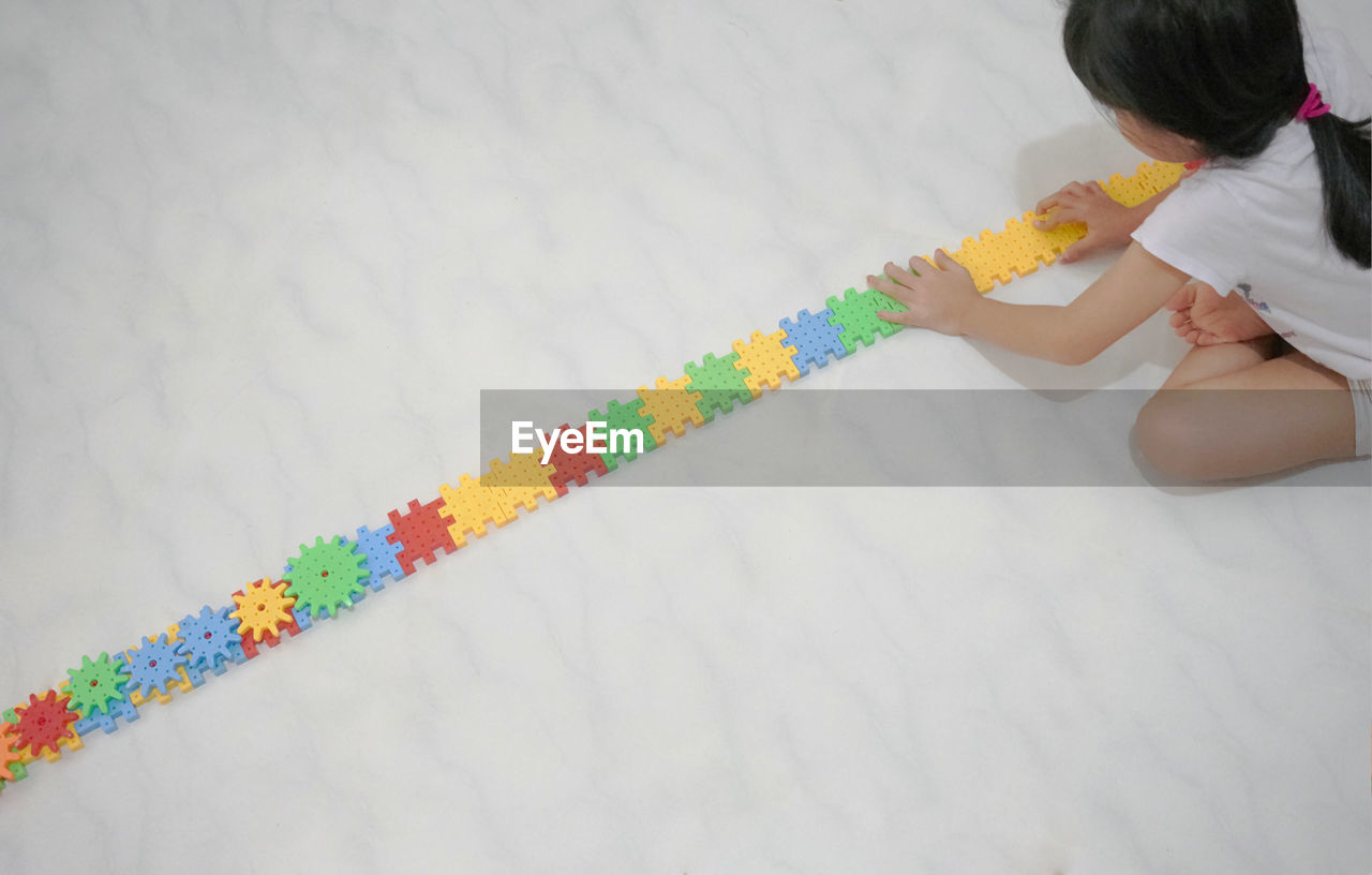 High angle view of girl playing with toy block at home