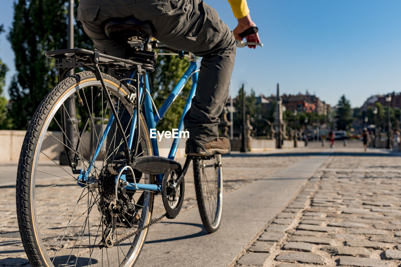 Unrecognizable man riding bicycle in the city. close up.
