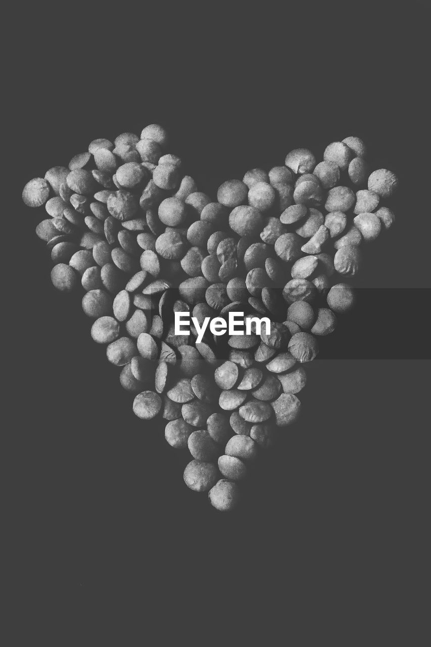 Heart shape made with beans over black background