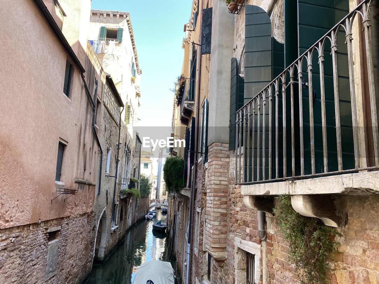 LOW ANGLE VIEW OF NARROW ALLEY AMIDST BUILDINGS