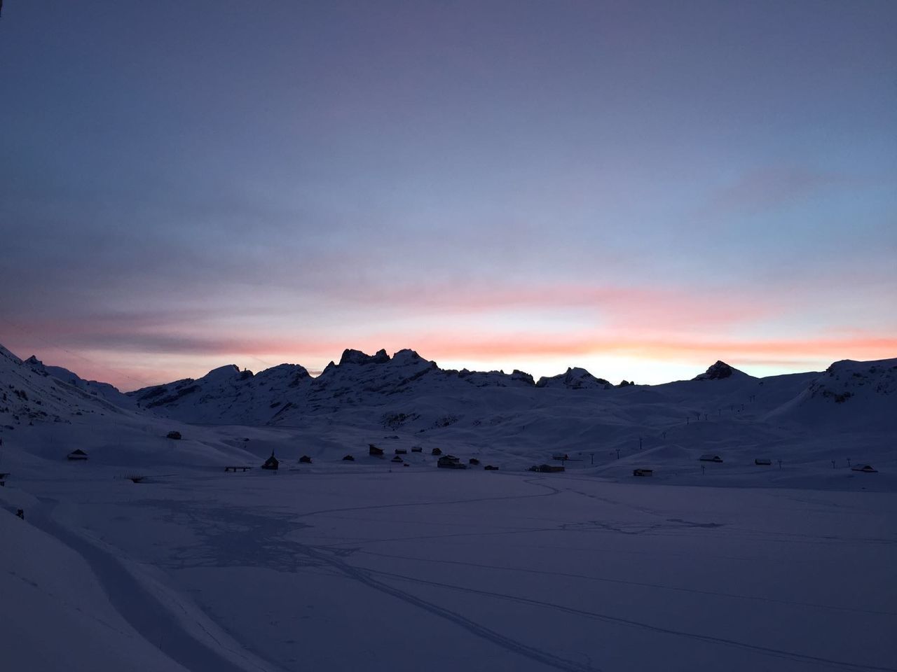 Scenic view of snow covered mountains against cloudy sky