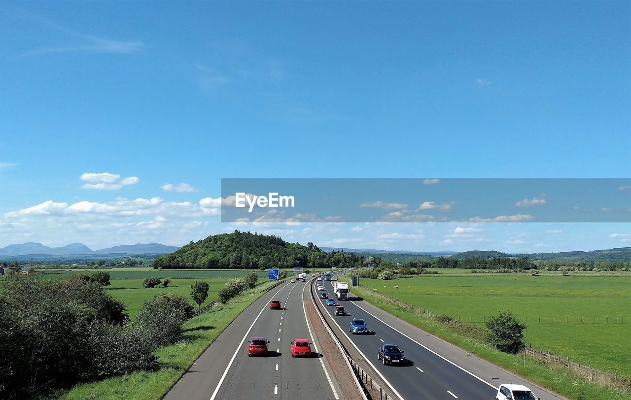 Vehicles on highway against sky