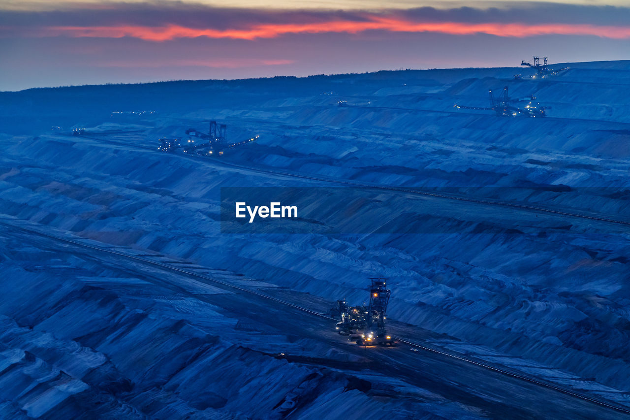 High angle view of illuminated coalmining dock against sky during sunset