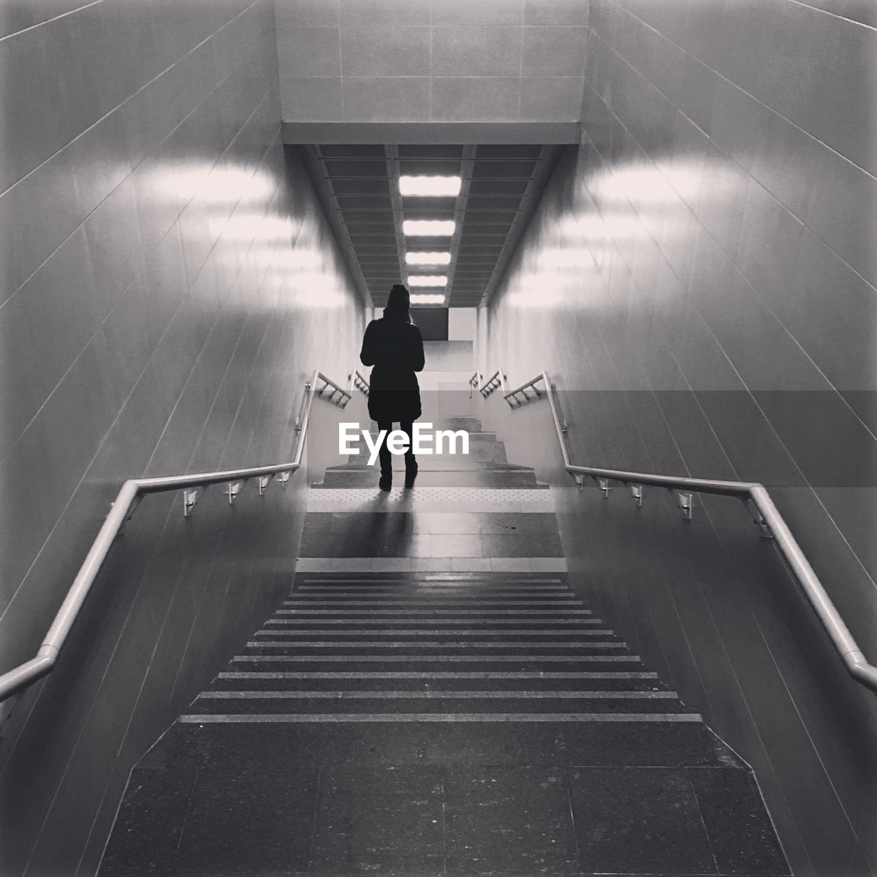 Rear view of woman walking in staircase