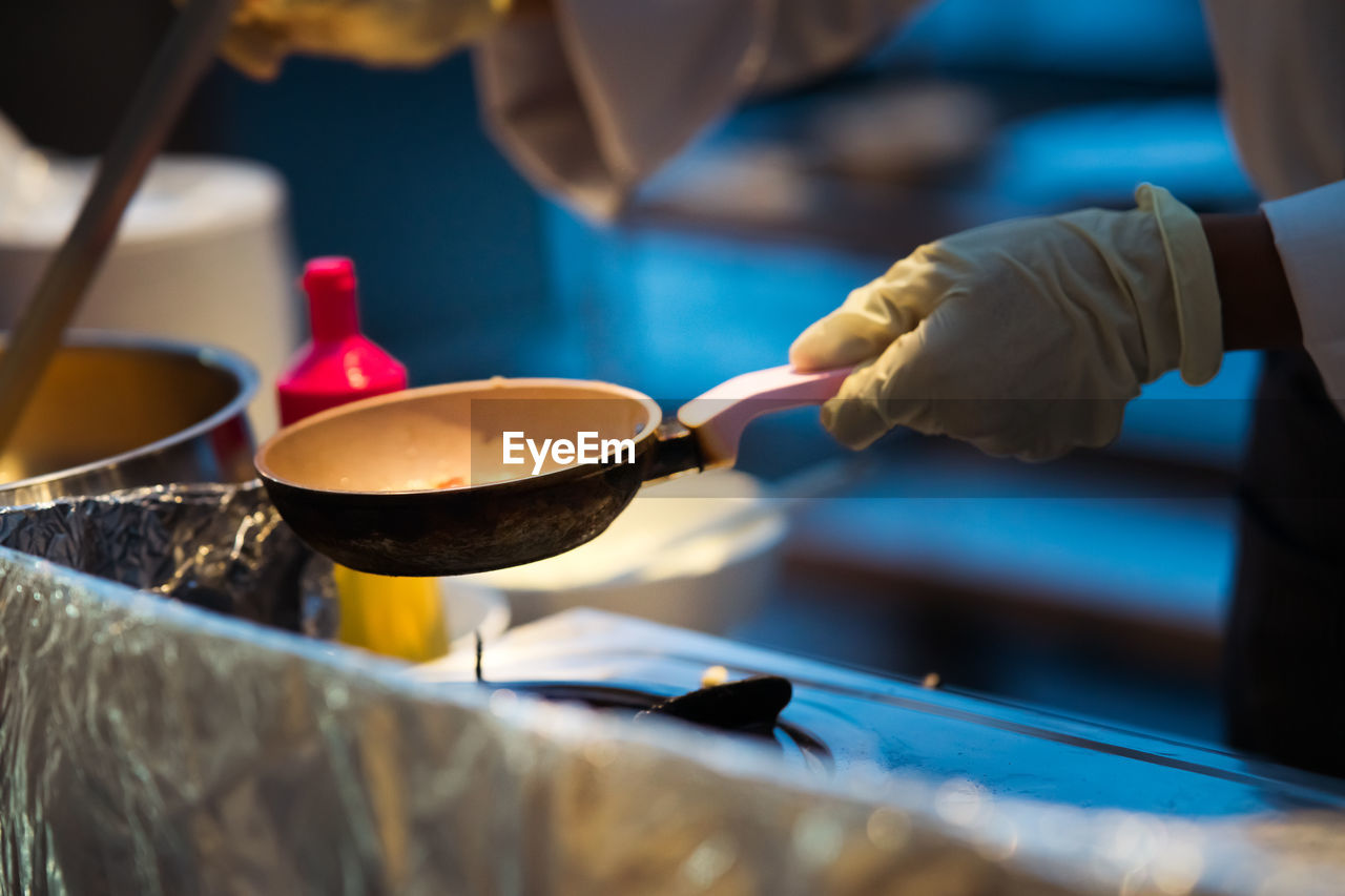 Making morning breakfast and placing omelets on the pan. wearing white gloves.