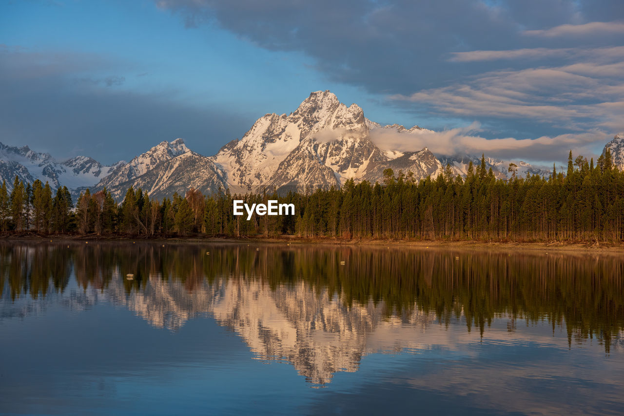 Scenic view of lake by mountains against sky