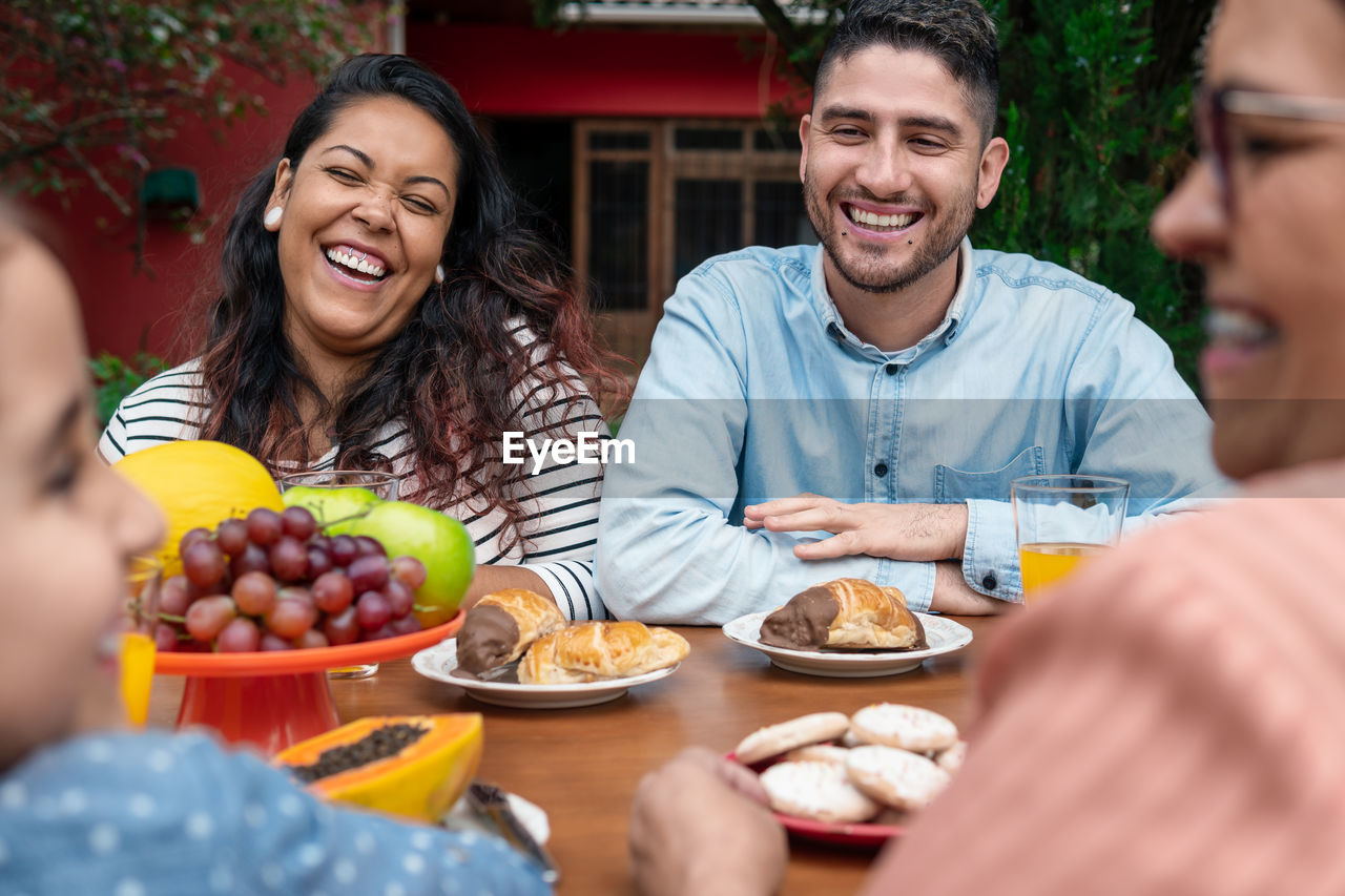 portrait of smiling friends having food in restaurant