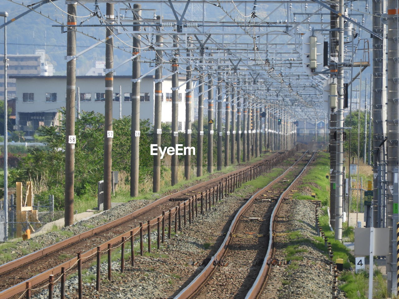 RAILROAD TRACKS IN CITY AGAINST CLEAR SKY