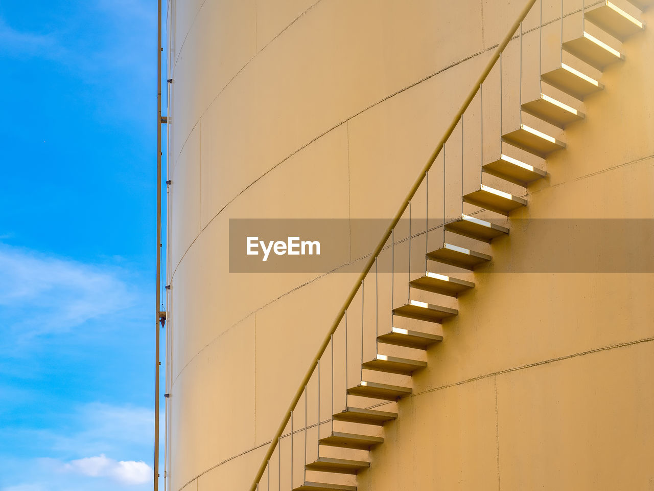 Low angle view of steps on silo against blue sky