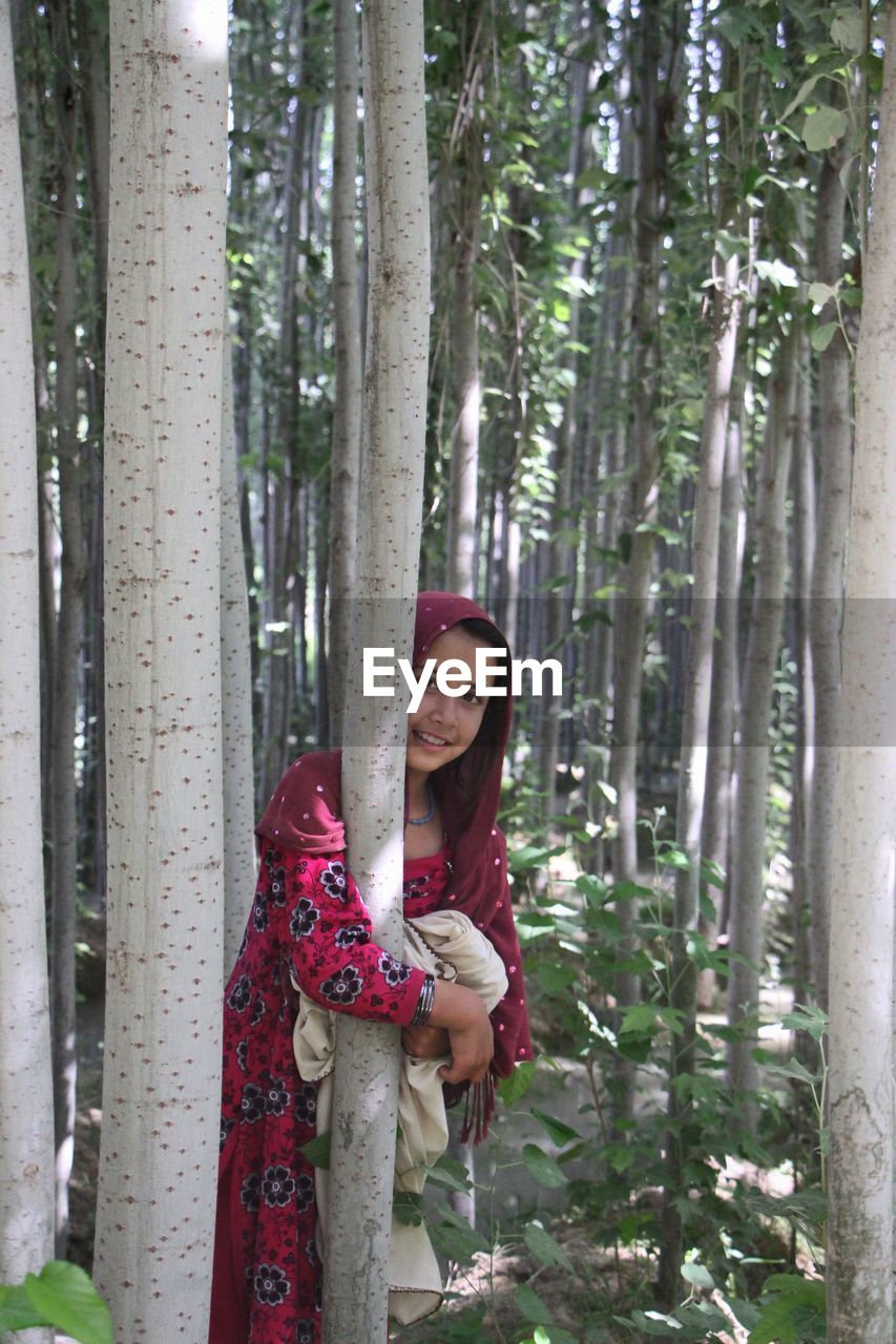 Portrait of afghan girl standing in forest