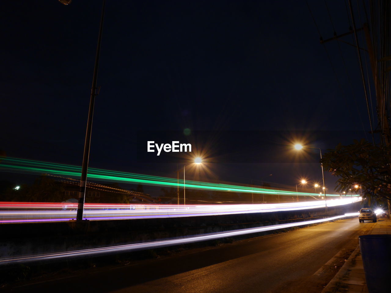 Light trails on road against clear sky at night