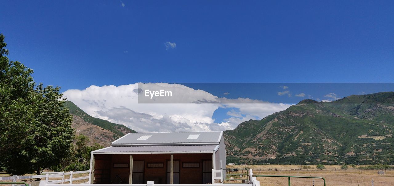 Scenic view of mountains and trees against blue sky