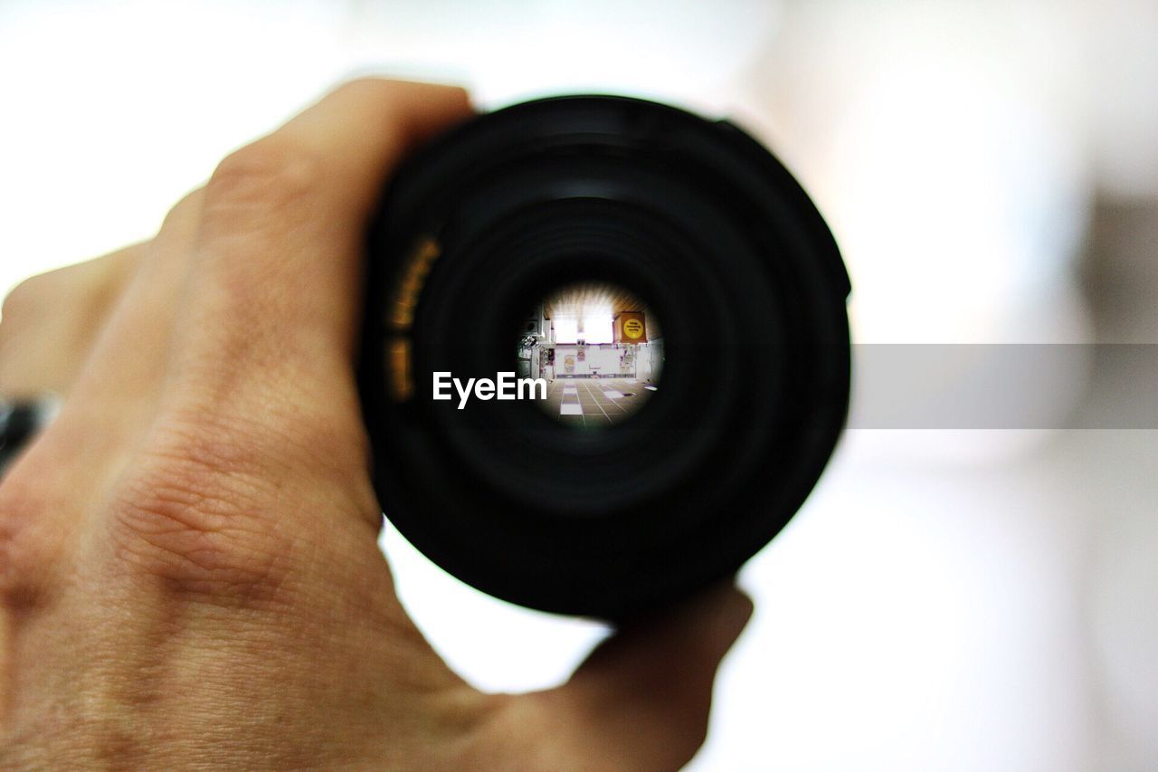 Cropped image of person holding a lens
