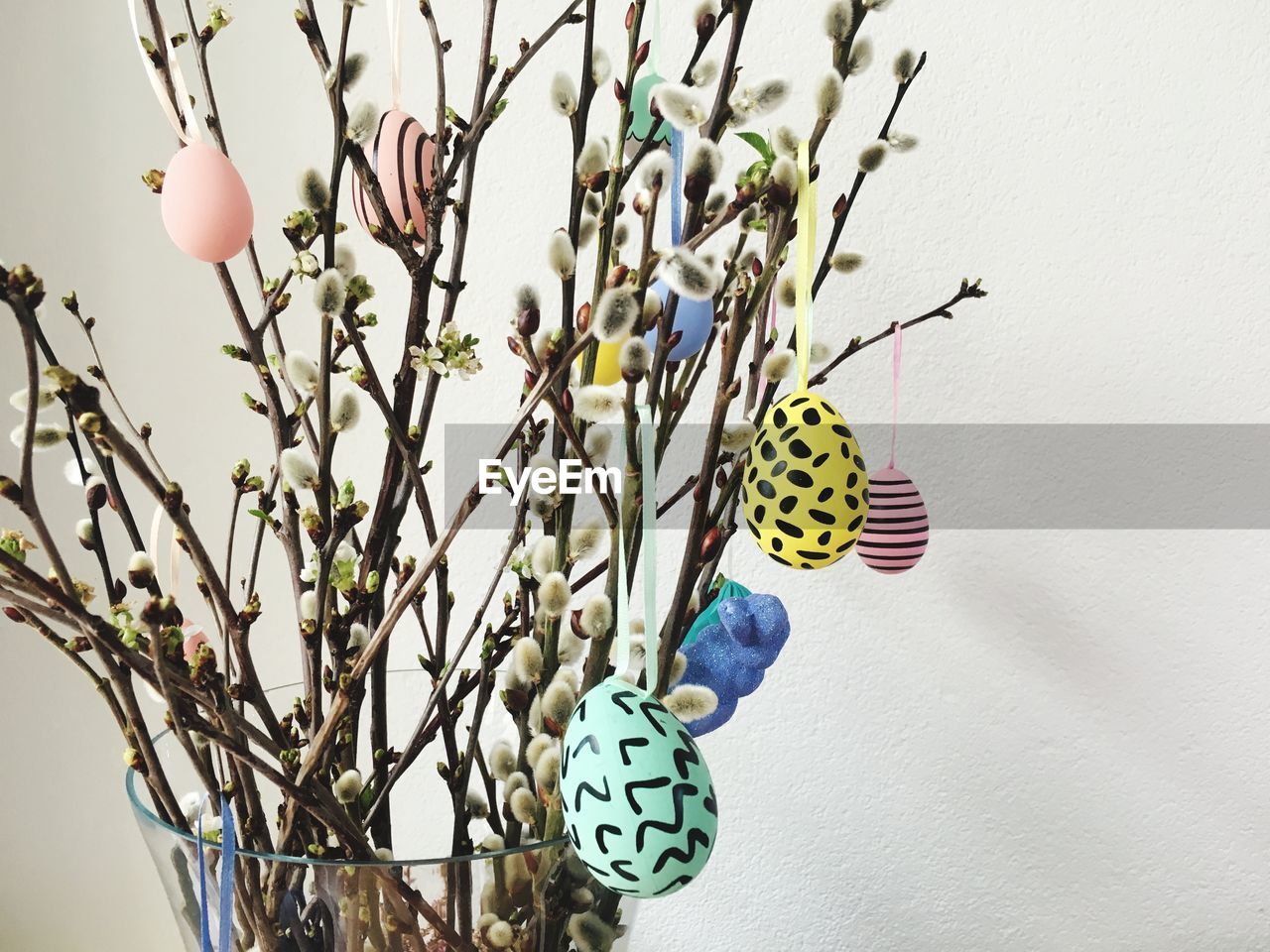 Close-up of easter eggs hanging from plants in vase