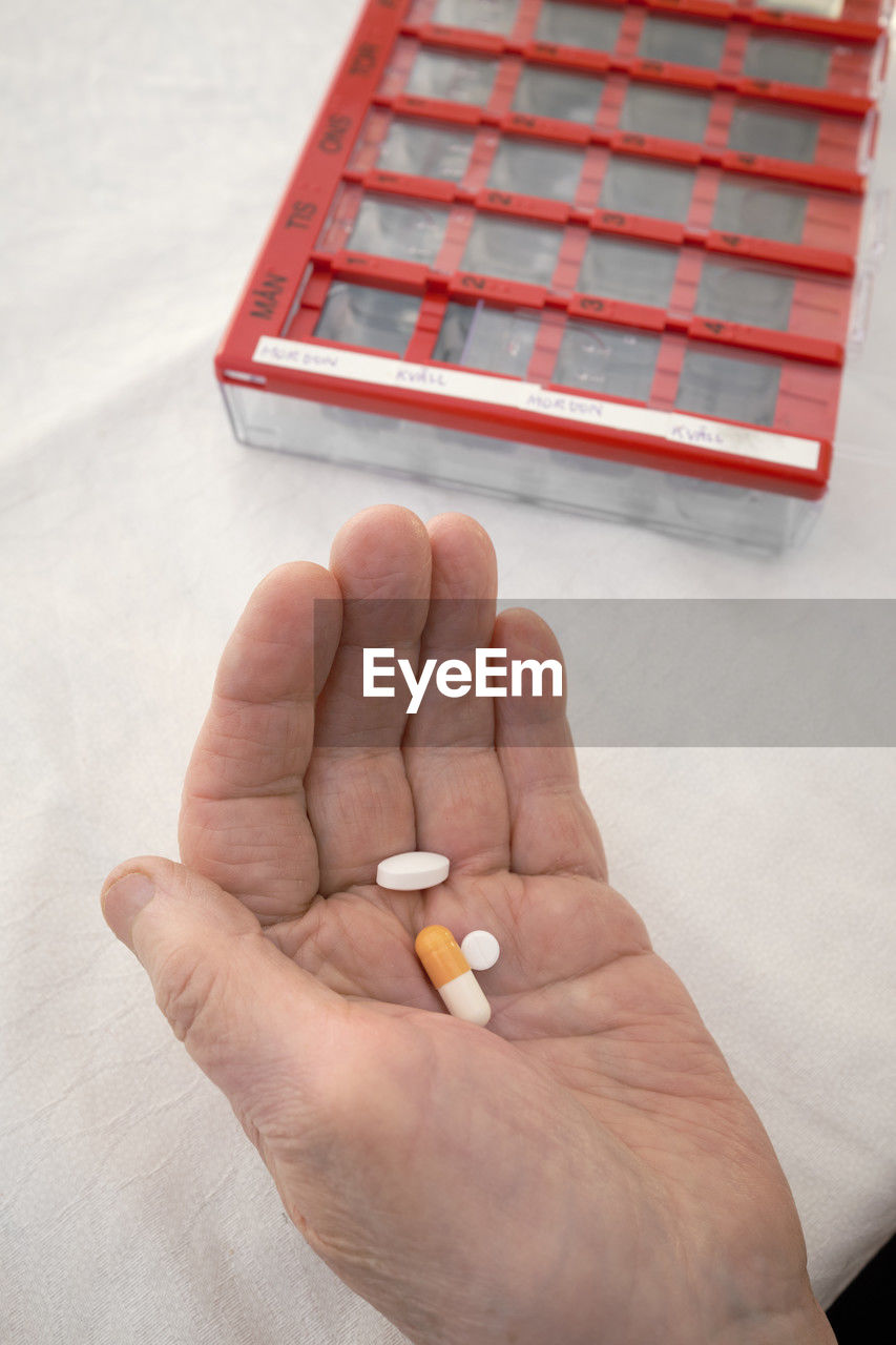 Close-up of person taking various medications