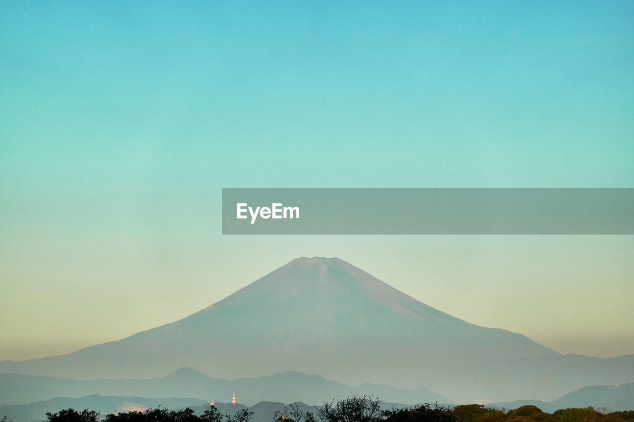 Scenic view of mountains against blue sky