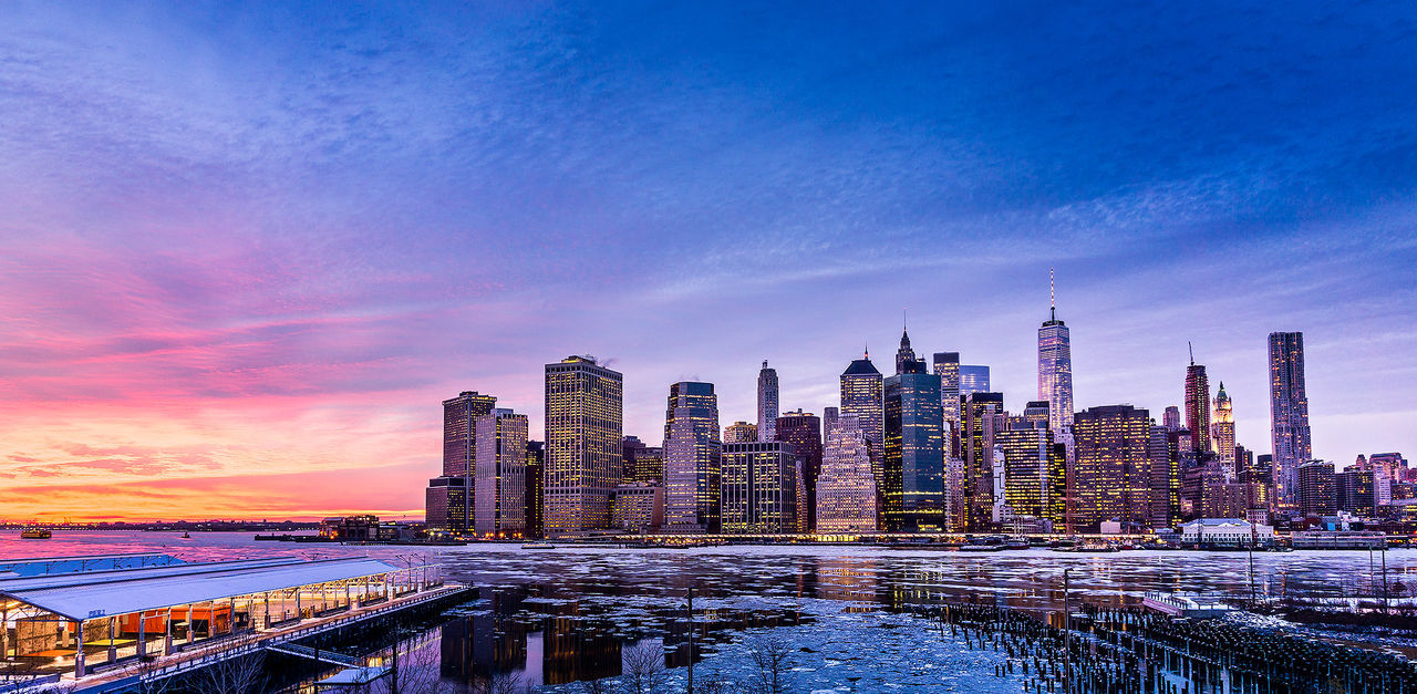 East river by modern city skyline against sky during winter