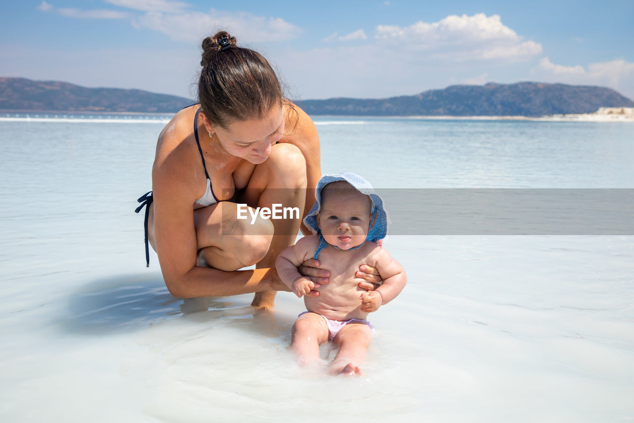 Father and son in water at shore