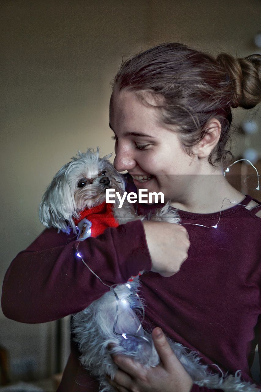 Smiling teenage girl holding dog