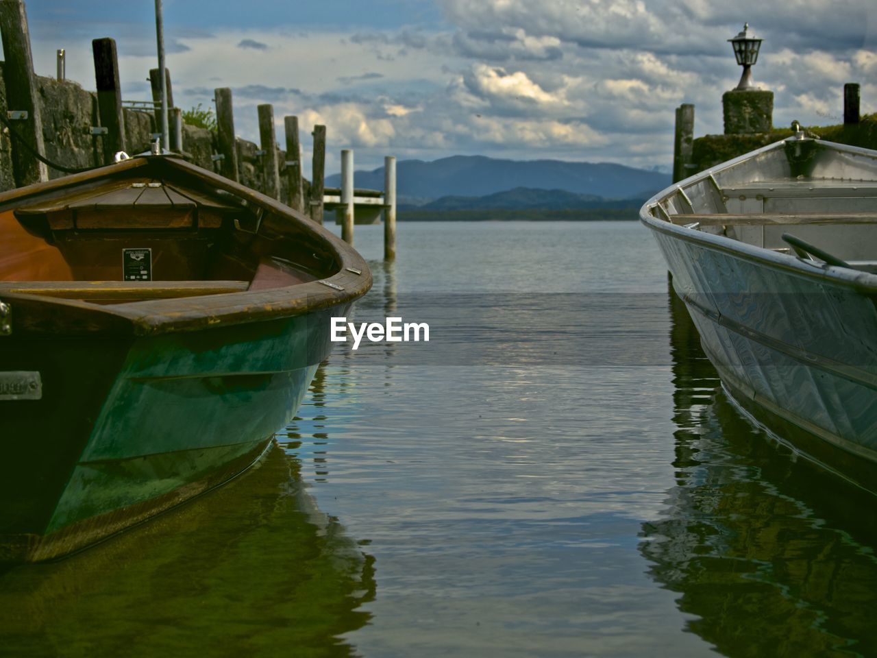 Boat moored on lake against sky