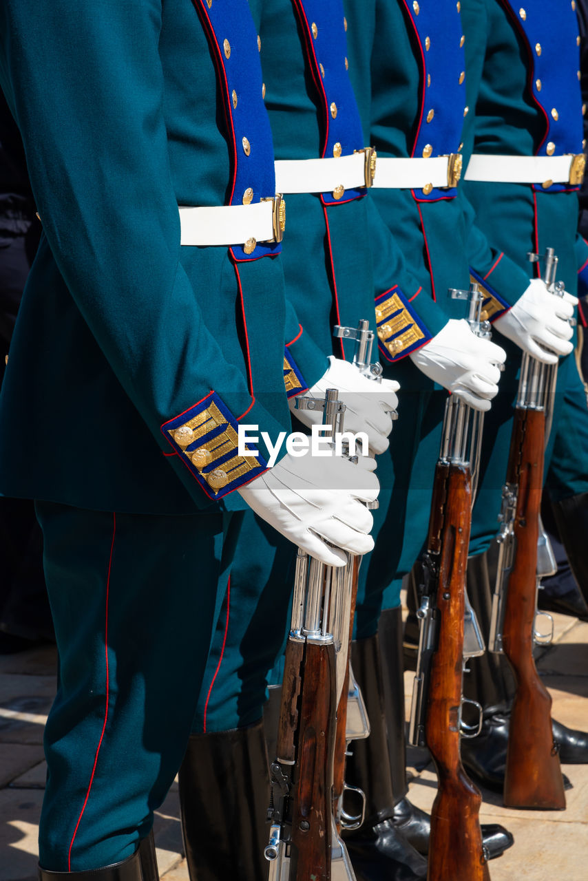 Low section of army soldiers with guns standing on street