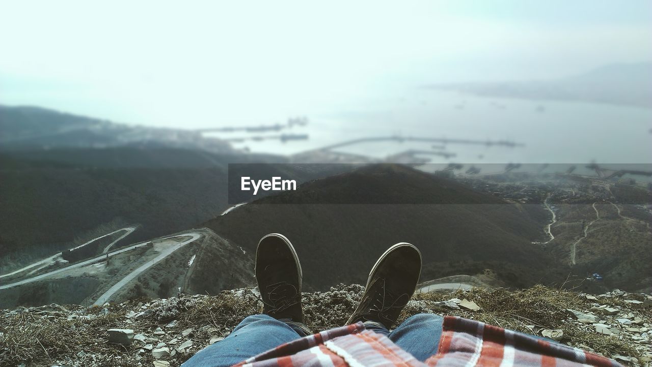 Close-up of legs against scenic background