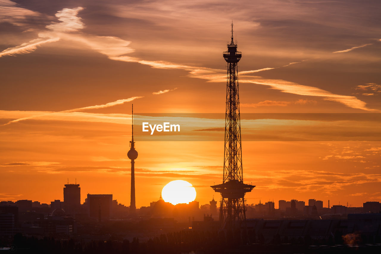 Silhouette fernsehturm and television tower against dramatic sky during sunset