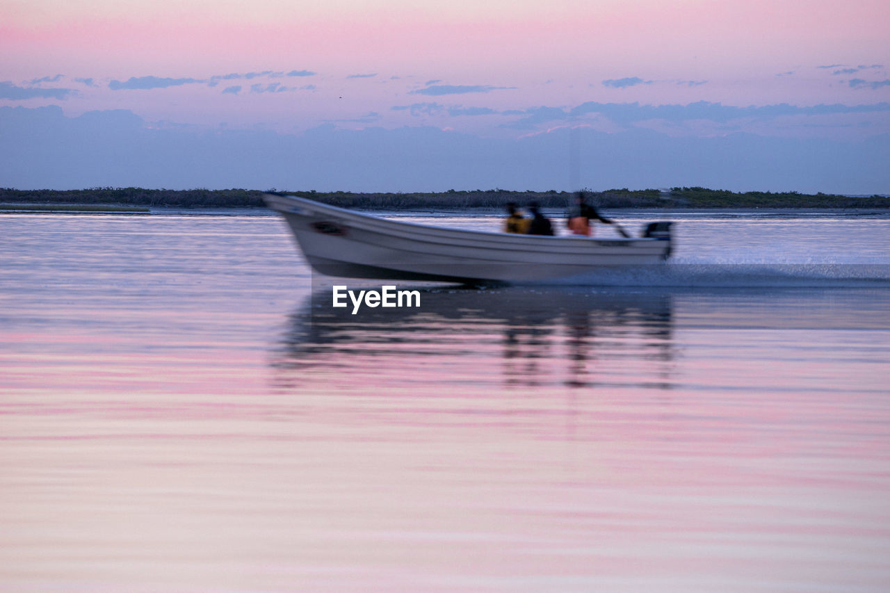 BOATS MOORED ON SEA AGAINST SKY DURING SUNSET