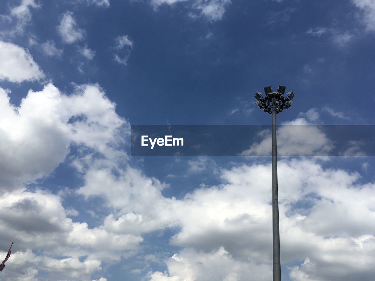 LOW ANGLE VIEW OF FLOODLIGHT AGAINST CLOUDY SKY