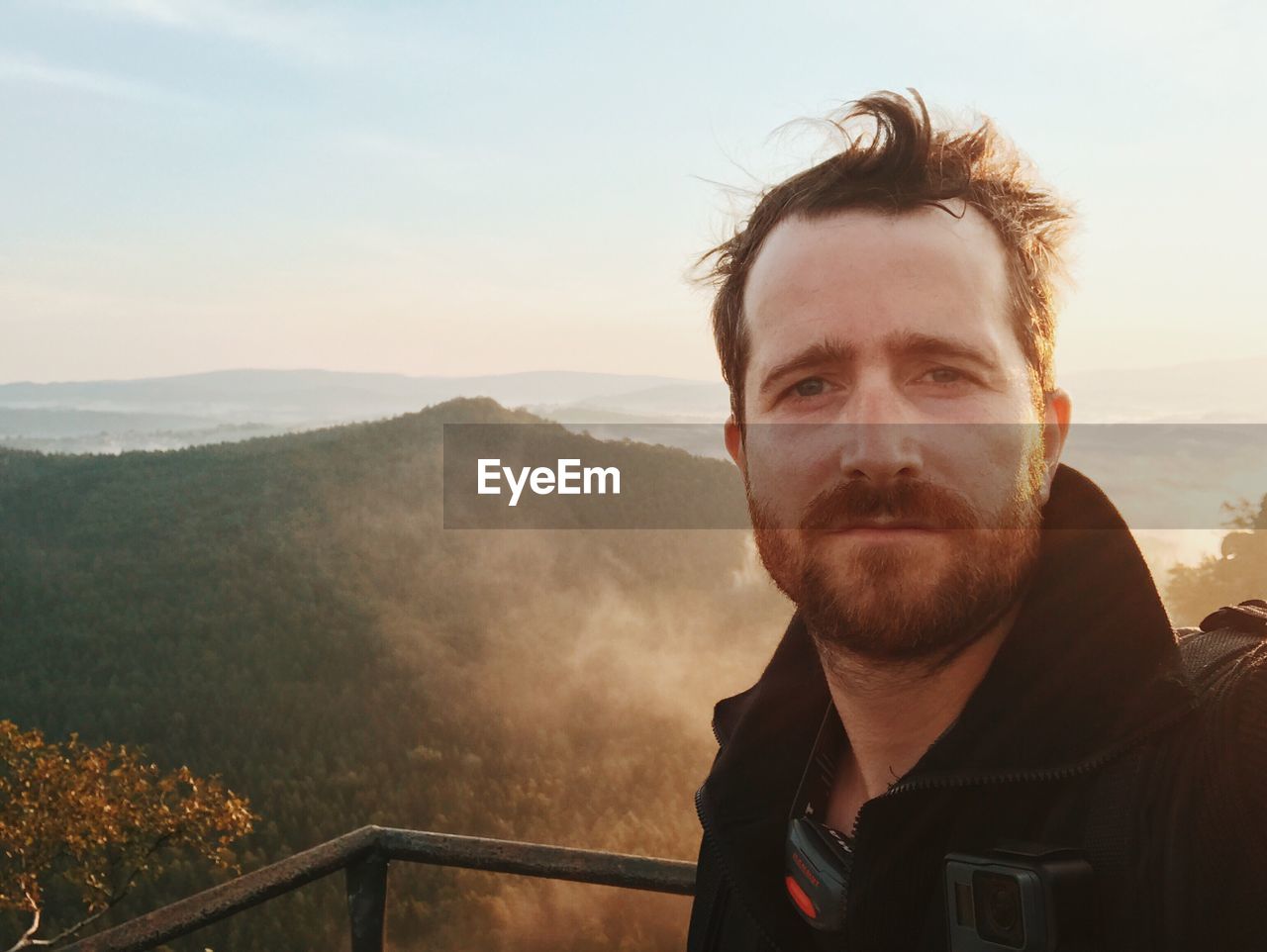 PORTRAIT OF MID ADULT MAN AGAINST MOUNTAINS