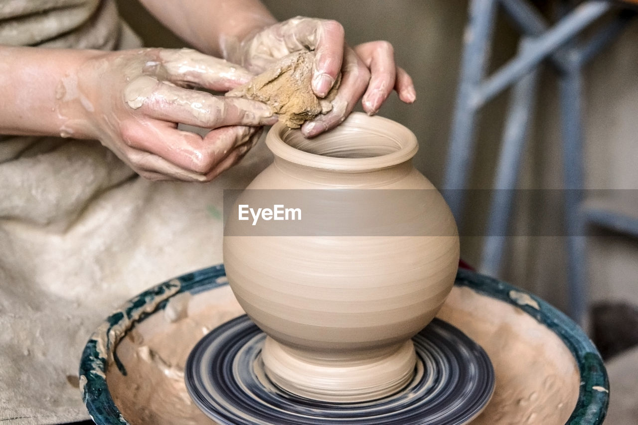 Making crock crude wet. man hands and tool making clay jug. sculptor in workshop makes jug of clay 