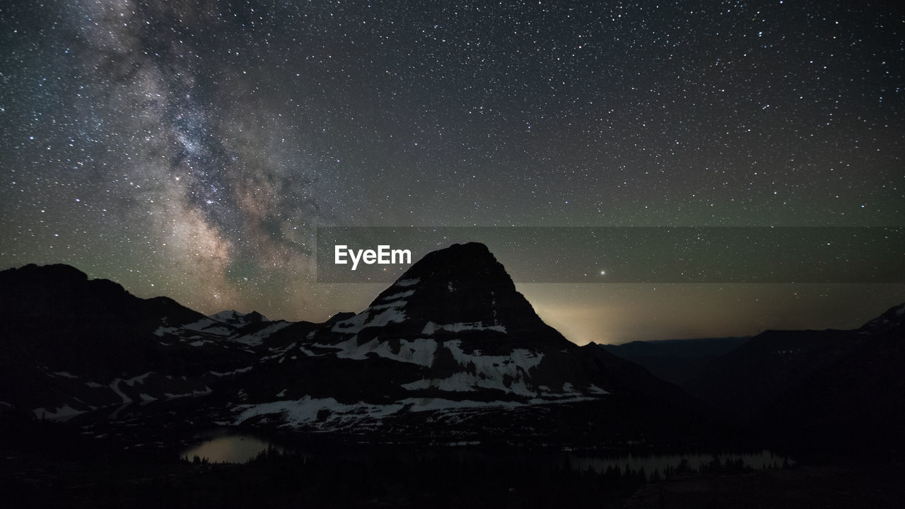 Scenic view of snowcapped mountains against sky at night