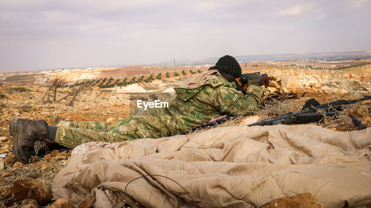 Full length of soldier observing field