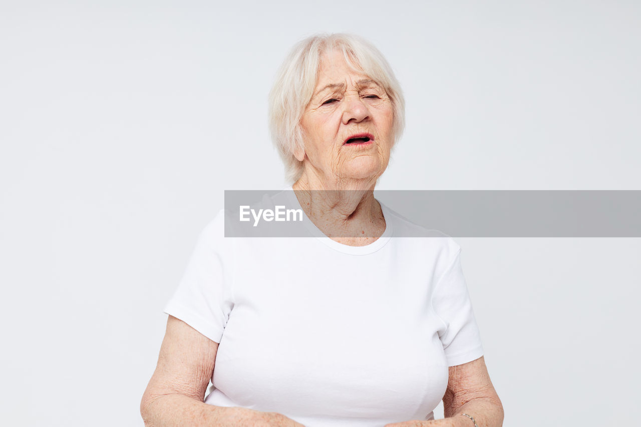 portrait of smiling young woman standing against white background