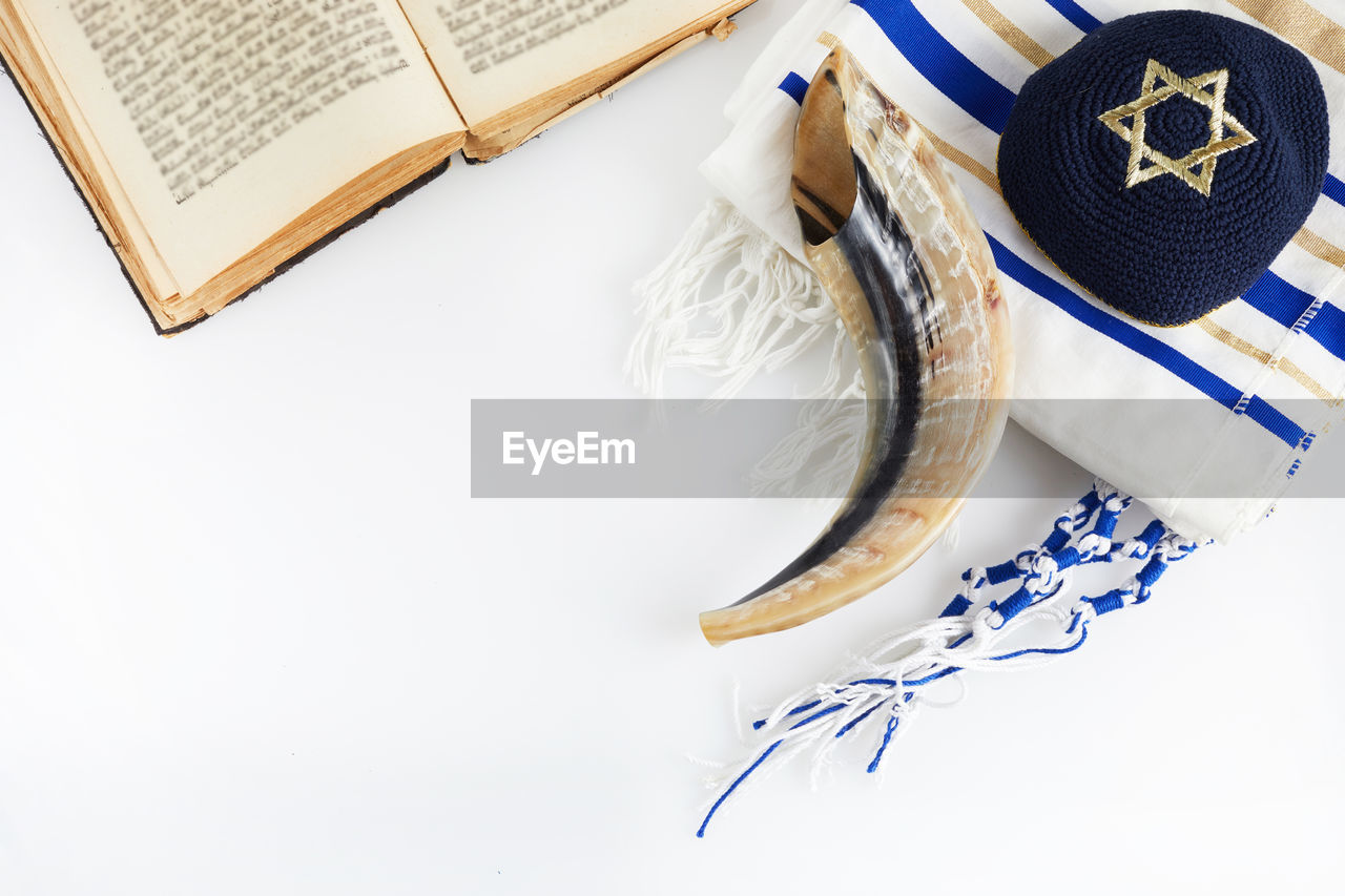 HIGH ANGLE VIEW OF BOOK ON TABLE AGAINST WHITE BACKGROUND