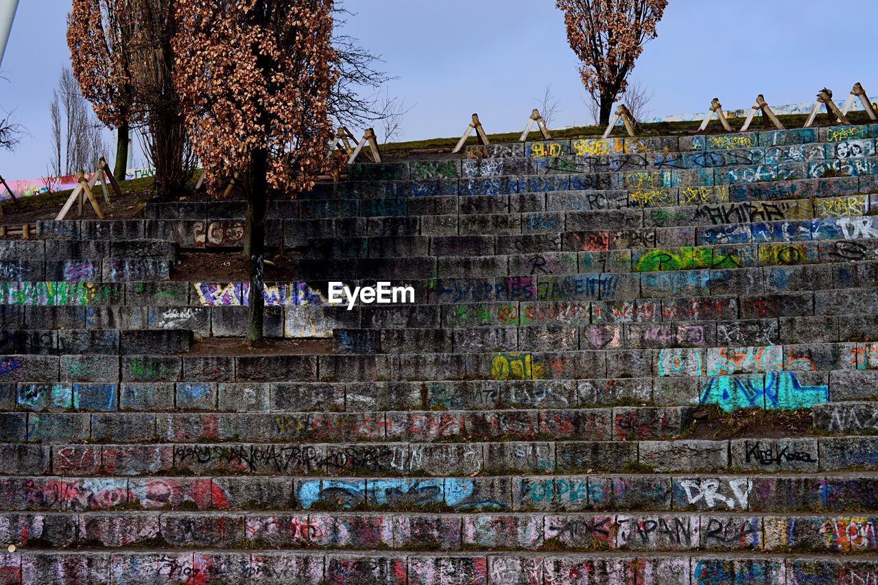 Graffiti on steps against sky at mauerpark