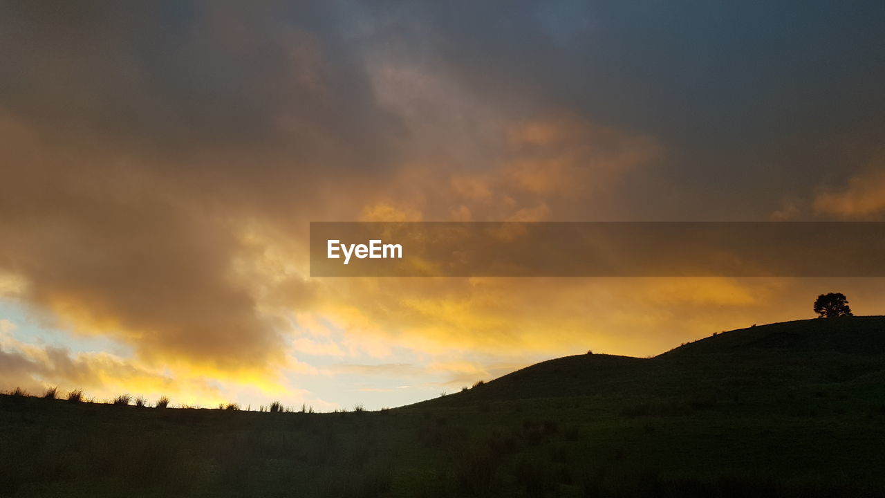 SCENIC VIEW OF SILHOUETTE MOUNTAINS AGAINST SKY DURING SUNSET